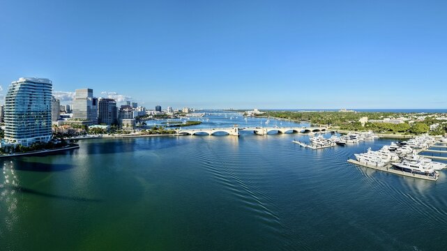 Aerial view of the Royal Park Bridge crossing Lake Worth Lagoon with the modern skyline and luxury yachts in the marina in Palm Beach, Florida, United States.