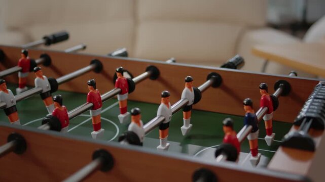 Foosball table game in motion capturing competitive spirit with spinning plastic players in action video footage
