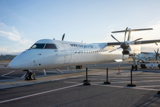 Portland, OR, USA - June 13, 2023: A Bombardier Q400 (De Havilland Canada Dash 8-400) high-speed, twin-turboprop regional airliner operated by WestJet, parked on the airport tarmac.