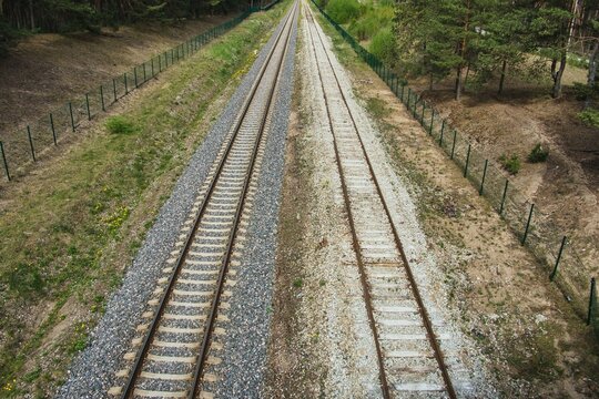 High angle view of parallel railway tracks stretching through a green landscape