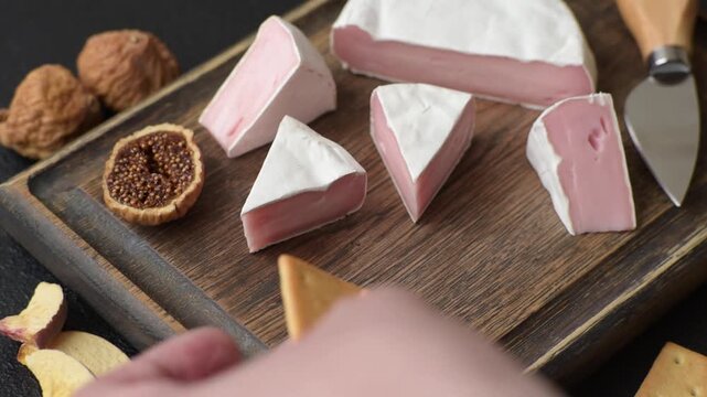 Pink Brie or Camembert cheese with honey, jam, figs, and crackers for a hearty breakfast. Brie cheese as a food background for your design