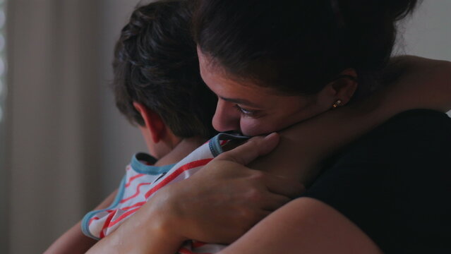 Mother embracing young child in close comforting hug expressing love protection and emotional reassurance creating tender family moment of safety and connection at home