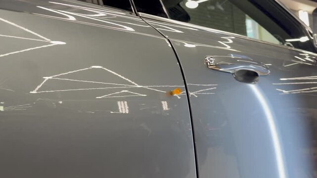 PDR. The mechanic at the auto shop with tools to repair dents in car body. Body repair. A specialist repairs a dent on the car body without painting. Paintless Car Dent Repair. 