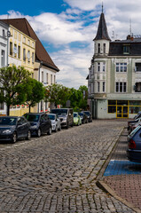 2025-05-04  Cobblestone street with parked cars and historic townhouses in Krapkowice Poland © fotomaster