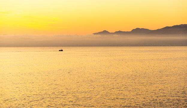 silhouette of fishing boat on walker bay, coastline of DeKelders, South Africa