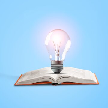 Light bulb glowing on an open book over blue background