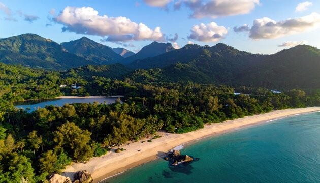 Lush green mountains meet a serene tropical coastline with a sandy beach