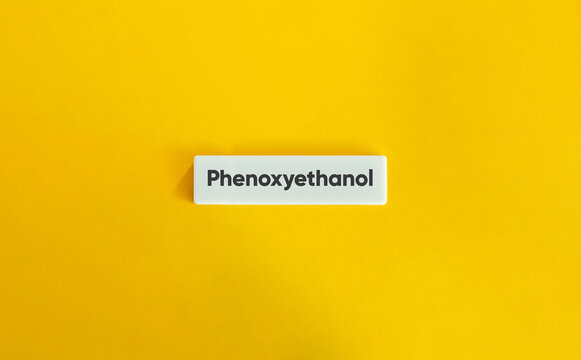 Phenoxyethanol Cosmetic Ingredient Text on a White Block Against a Bright Yellow Background