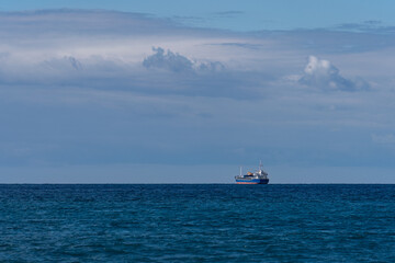 Fototapeta premium Blue freighter on open ocean