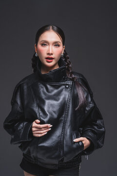 Expressive Asian woman in leather jacket for high fashion cosmetics marketing campaign luxury streetwear aesthetic modern urban lifestyle casual portrait studio