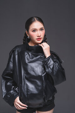 Expressive Asian woman in leather jacket for high fashion cosmetics marketing campaign luxury streetwear aesthetic modern urban lifestyle casual portrait studio