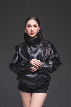 Expressive Asian woman in leather jacket for high fashion cosmetics marketing campaign luxury streetwear aesthetic modern urban lifestyle casual portrait studio