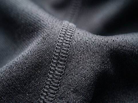 Black athletic fabric texture with flatlock seam, breathable mesh polyester material for sportswear, macro view of technical performance textile