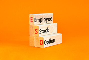 Naklejka premium ESO employee stock option symbol. Concept words ESO employee stock option on beautiful wooden blocks. Beautiful orange background. Business ESO employee stock option concept. Copy space.