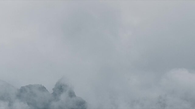 Mountain Peak Emerging Through Gray Clouds and Mist