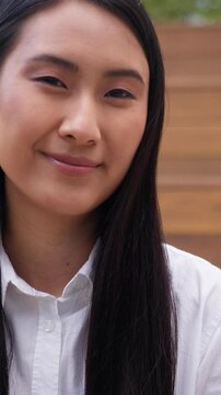 Pensive smiling Asian Korean Chinese business woman looking at camera calm smile in city Japanese female businesswoman girl worker manager posing outside in downtown happy agent employer lady portrait