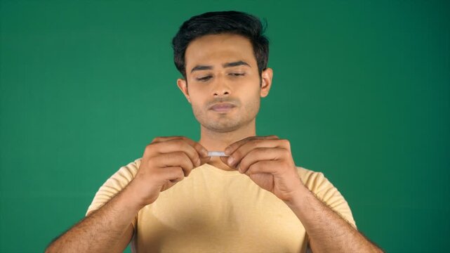 A handsome Indian man breaking a cigarette butt into two halves. Smoking is injurious to health - tobacco issues and healthcare  smoking kills  quit smoking  bad habit