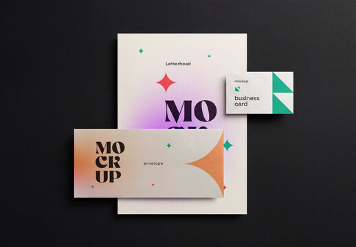 Top view of a minimalist corporate stationery branding mockup featuring a letterhead paper, a horizontal envelope, and a business card on a solid black background