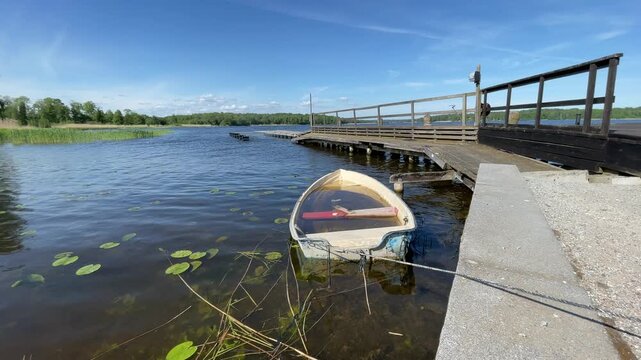 Sunny summerday at a lake with wooden bridge. Old sinking boat. M&auml;laren, Skokloster, Sweden. June 2026.