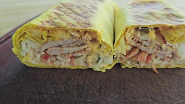 Enjoying a fresh wrap filled with chicken and vegetables at a local eatery in the afternoon sun
