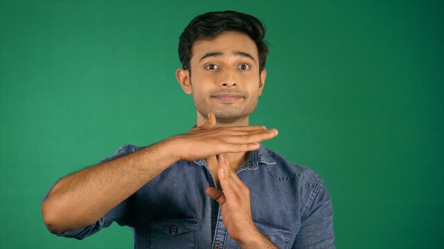 Portrait of a handsome boy making a time out gesture. Green screen / Chroma shoot. Attractive guy with stubble posing for the camera - modern lifestyle  break time  pause