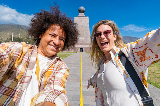 Diverse friends celebrating on the equator line at mitad del mundo under a clear sky