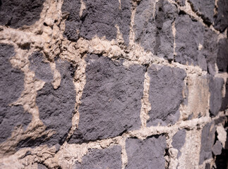 Fototapeta premium Close-up of concrete block masonry with wide mortar joints and rough texture. Detailed view of traditional wall construction, building material background with copy space.