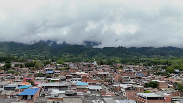 drone footage of Lago Calima Darien town in valle del cauca colombia with clouds rolling over green mountains