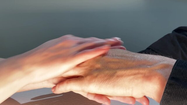 Hands massage wrist in close up. Gentle skincare or therapy motion continues on bare skin. Wellness, relaxation, and personal care concept..