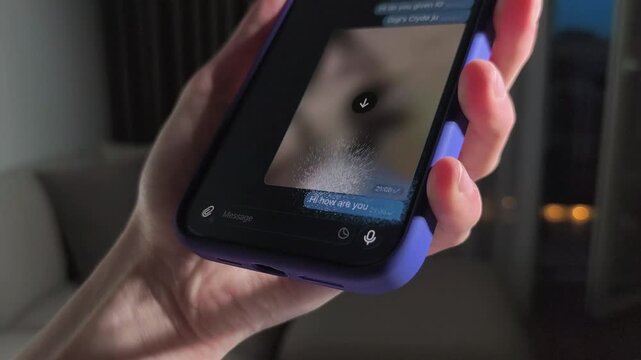 Hand holds smartphone and deleting voice message in messenger app. Messaging, social media, and app navigation concept..