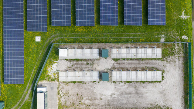 Aerial drone view of renewable battery storage at a solar park, balancing the grid and preventing net congestion in The Netherlands.