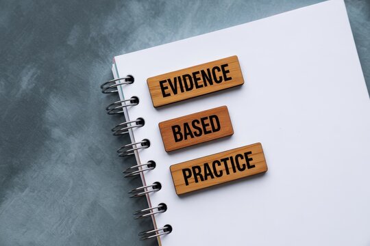 Evidence Based Practice text on wooden blocks on a spiral notebook