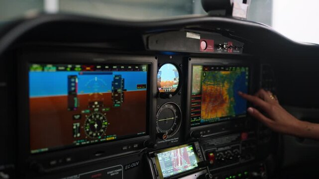 Pilot operating touchscreen navigation system in cockpit
