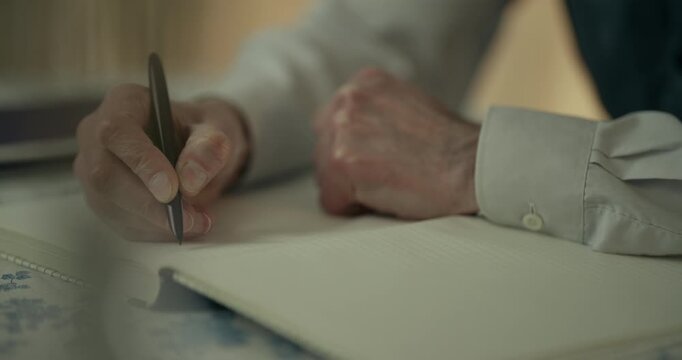 Hands reviewing paper beside laptop on office desk