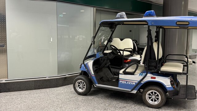 Police Patrol Cart in Airport: A compact police patrol cart, equipped for security operations, is parked in a modern airport terminal. Airport Malpensa, Milan, Italy 
