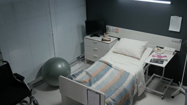 Empty hospital maternity ward room showing bed,fitness ball,and wheelchair prepared for childbirth. Footage is suitable for healthcare marketing and medical insurance commercials, high angle