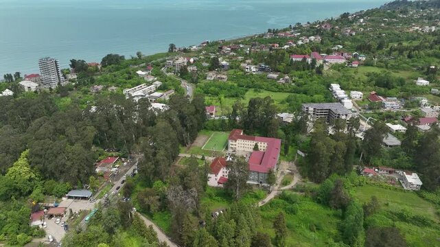 Chakvi, Georgia &mdash; May 22 2026: Aerial drone view of Public School N1 building complex surrounded by lush green trees and coastal landscape in Adjara region.