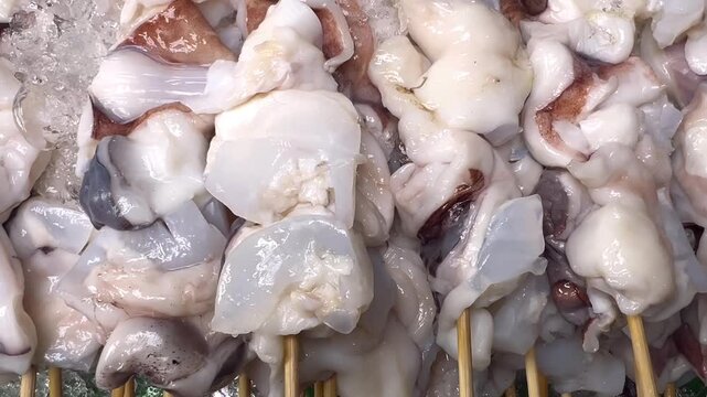 Fresh Raw Octopus Skewers on Ice Ready for Grilling at Seafood Market