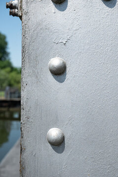 Rounded heads of industrial bolts on suspension bridge