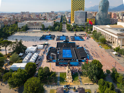 Tirana, Albania - 29 May 2026: Aerial view of the FIP Platinum Padel Tournament in Skanderbeg Square with blue courts, historic buildings, and people walking under a clear sky.
