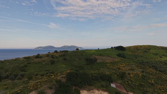 Aerial view of the lush green hills and yellow wildflowers of Sazan Island overlooking the Adriatic Sea in Vlore, Vlore County, Albania.