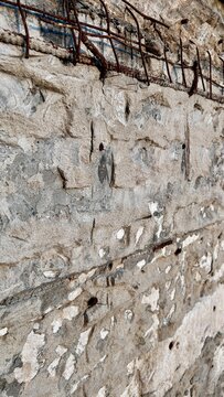 rusty rebar grid embedded in cracked concrete wall with copy space