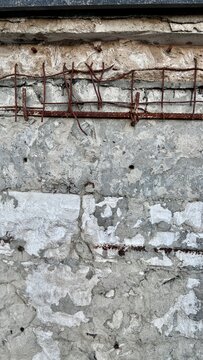 rusty rebar grid embedded in cracked concrete wall with copy space