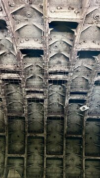 the concrete ceiling of a subway tunnel with grid reinforcement in weathered gray tones with copy space