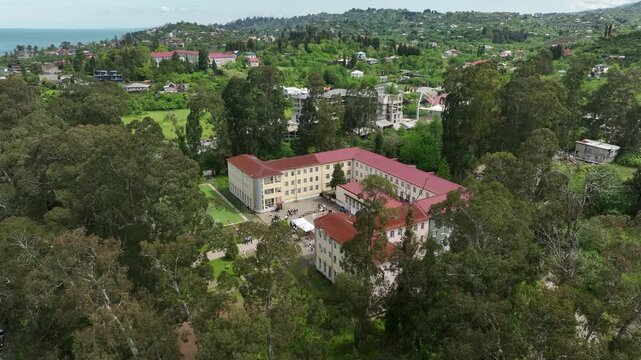 Chakvi, Georgia &mdash; May 22 2026: Aerial drone view of Public School N1 building complex surrounded by lush green trees and coastal landscape in Adjara region.