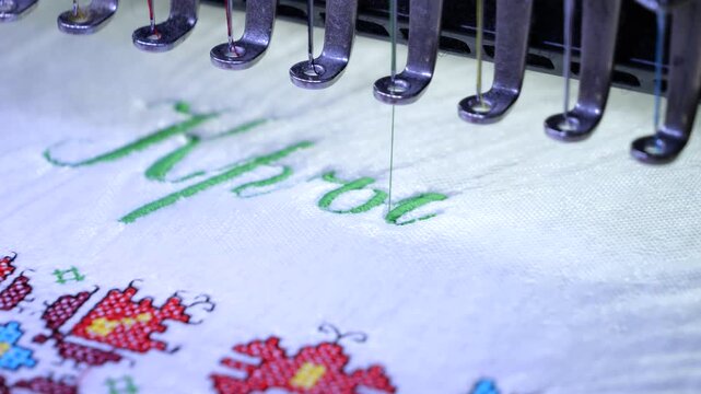 Machine embroidery of the inscription Holy Baptism with colored threads on a white terry cloth. Baptism cloth with cross stitch for Bulgarian tradition. 4k video.