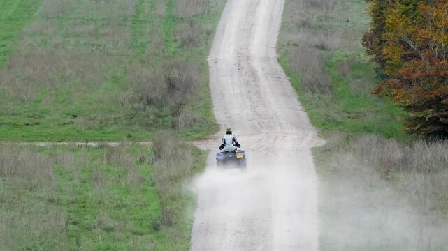 a quad biker riding his off-road quad bike along a stone track open countryside