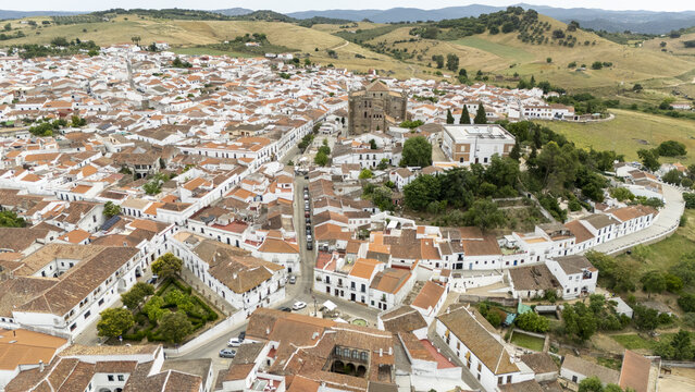 Aerial view of white houses with terracotta rooftops and the Parroquia de Nuestra Senora de la Consolacion in Cazalla de la Sierra, Andalusia, Spain.