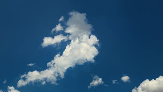 Time lapse of fluffy white clouds moving rapidly across the bright blue sky creating a beautiful cloudscape