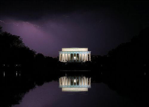 Lincoln memorial at night with summer storm, purple lightning above and behind, Reflecting Pool
